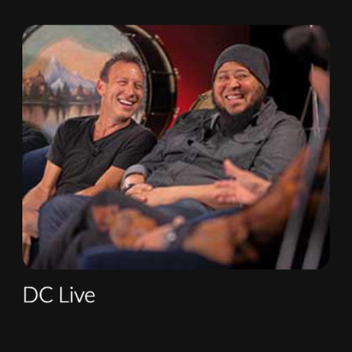 DC-Entertainment _ DC Live Two artists sitting and laughing with text "DC Live".
